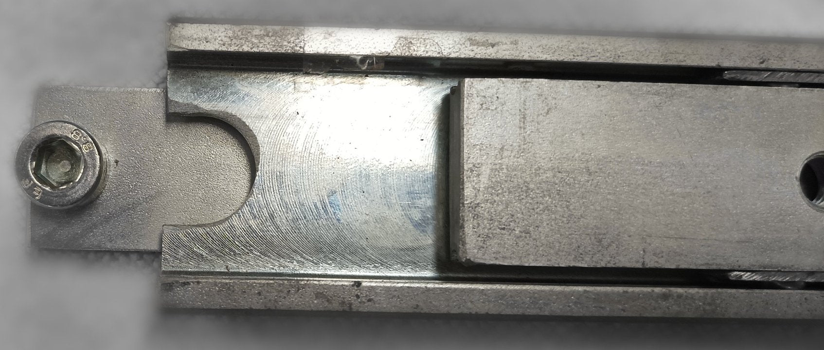 Close-up of a heavy-duty telescopic drawer slide made of steel, showing the slide's full extension mechanism.